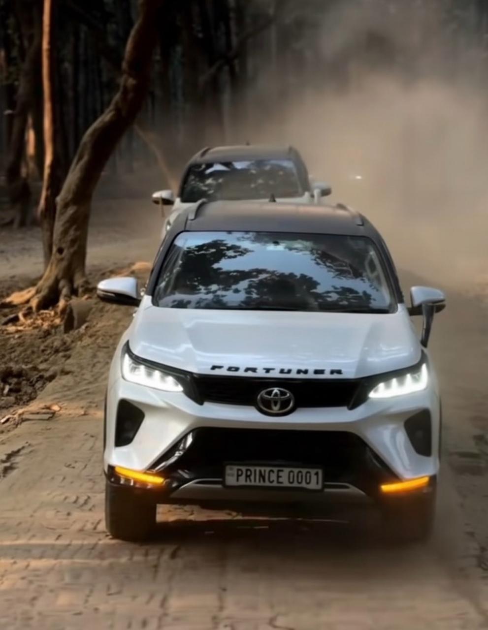 Prince Choudhary's Fortuner leading on a forest trail with dust